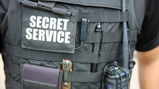 Picture shows an up close shot of a secret service man wearing his bullet proof vest. 