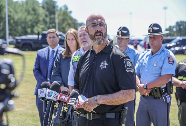 This is a photo of a Police Sherriff talking outside at a press conference.