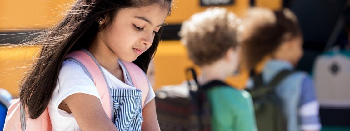 girl-waiting-to-board-school-bus-1200x450